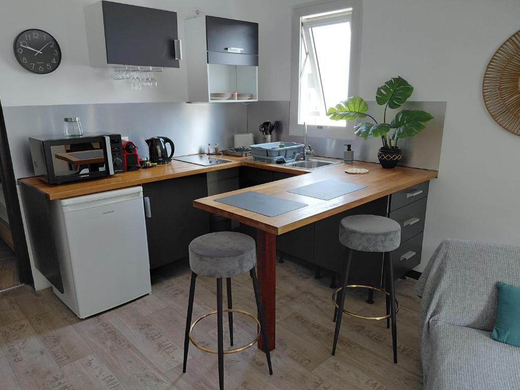 a kitchen with a table and two bar stools at Papaya in Noumea