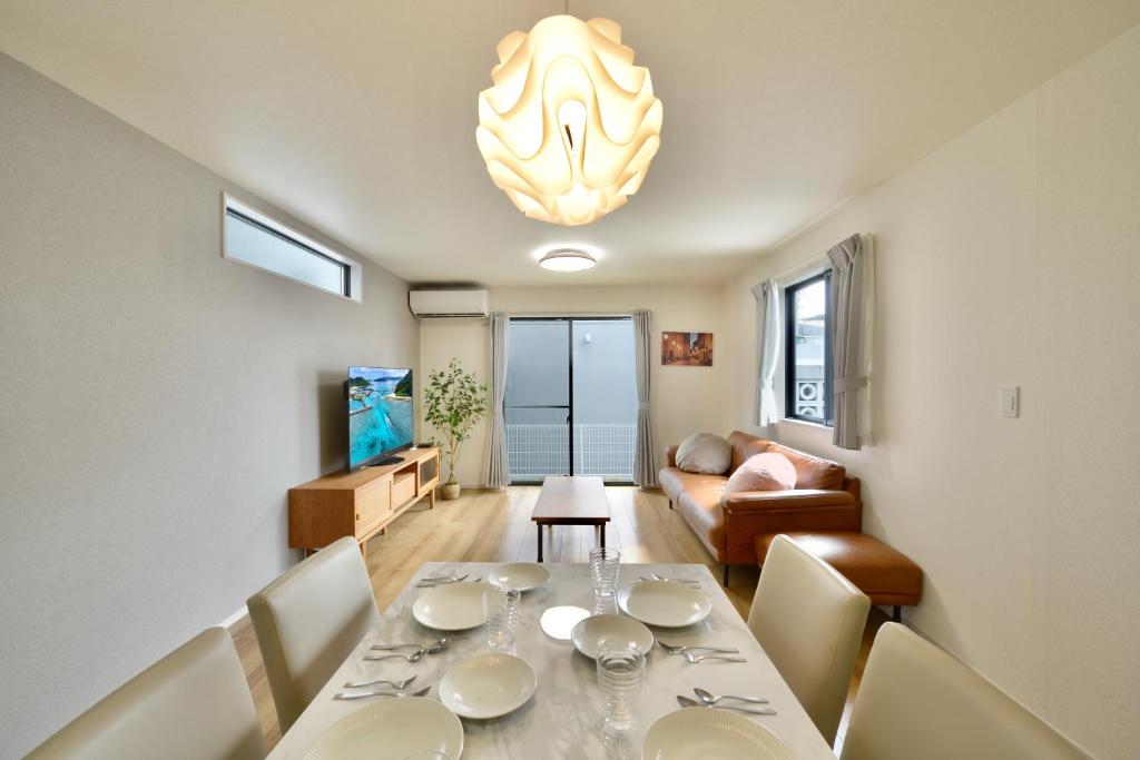 a dining room with a table and a living room at Aiki No Yado-Kokuba- in Naha