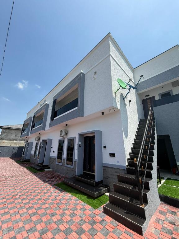 a white house with a staircase in front of it at House 9 Signature in Port Harcourt