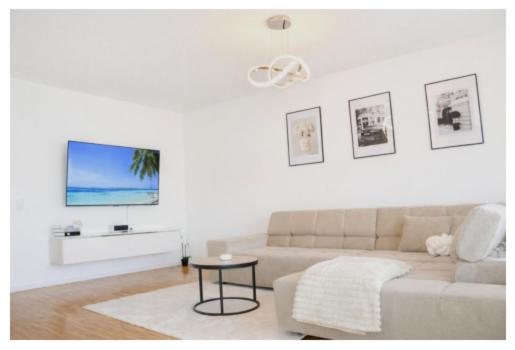 a white living room with a couch and a table at Ferienwohnung Südwind 3 in Küssaberg