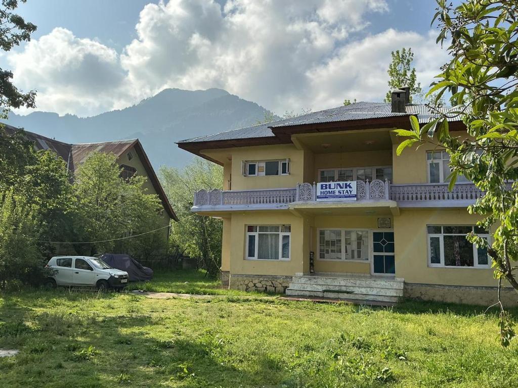 a yellow house with a sign on the front of it at Bunk Home stay in Srinagar