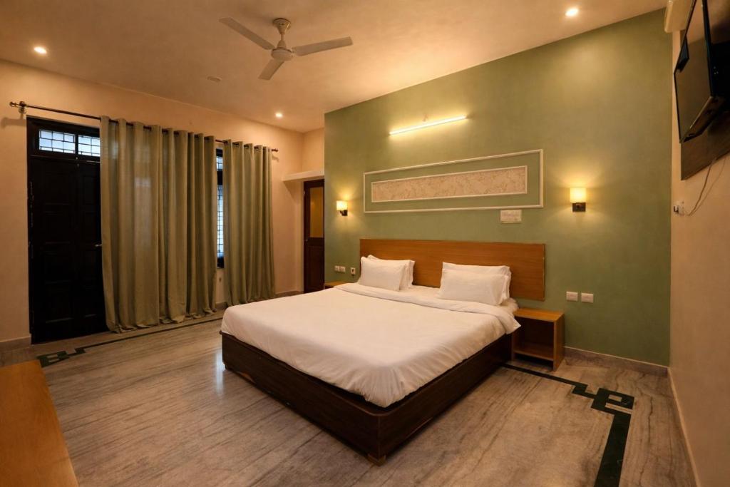 a bedroom with a bed and a ceiling fan at Heritage Inn in Lucknow
