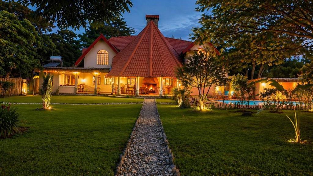a house with a pathway leading to the front yard at Kitunduni Lodge in Arusha