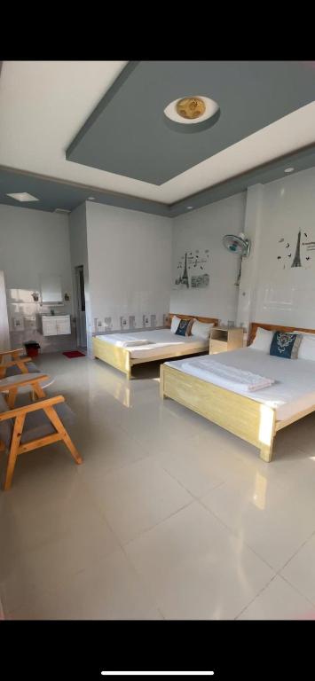 two beds in a large room with a ceiling at Homestay canthoriver in Ấp Bình Lạc