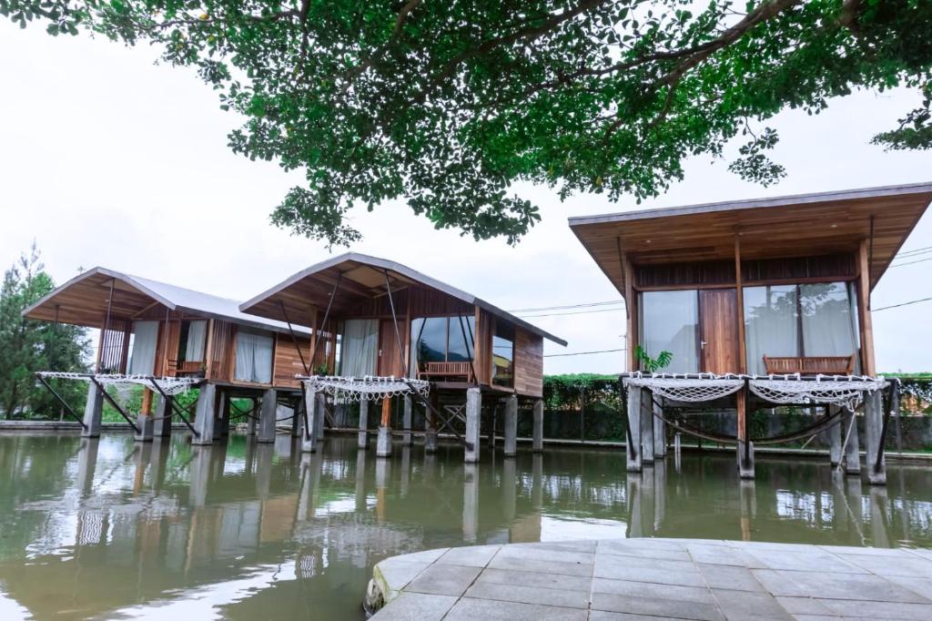 a row of cottages in the water at Saung Komando Ciwidey in Winducina