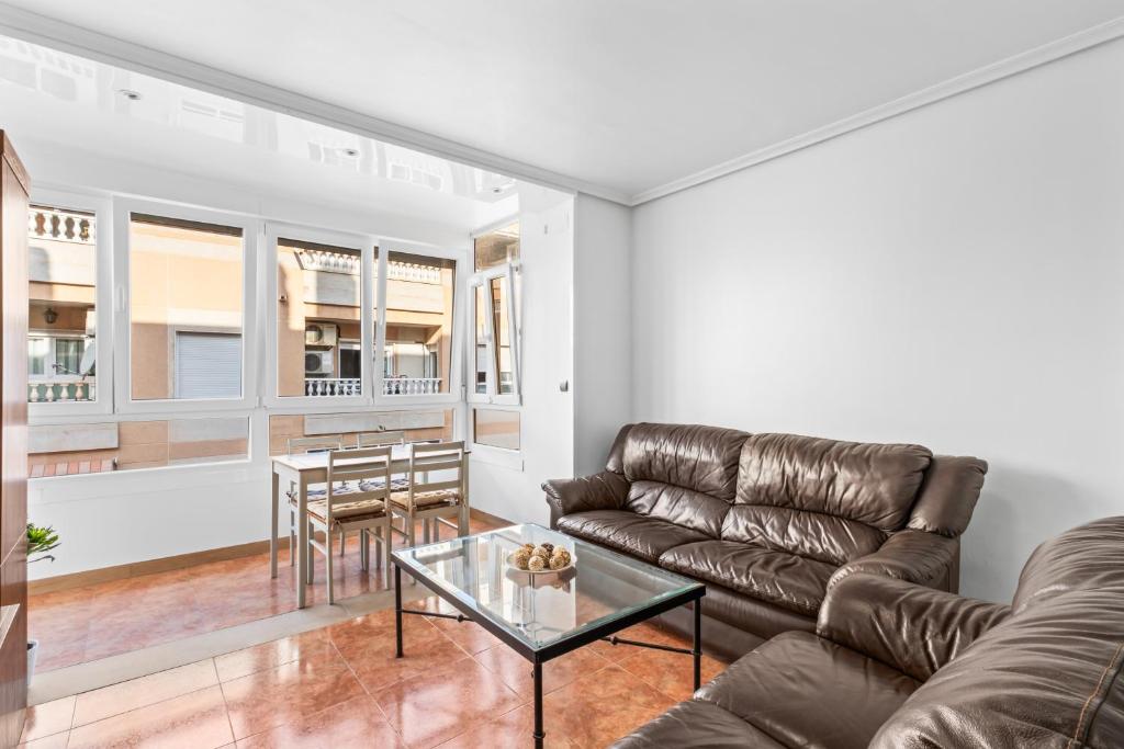 a living room with a leather couch and a table at Zoa in Torrevieja