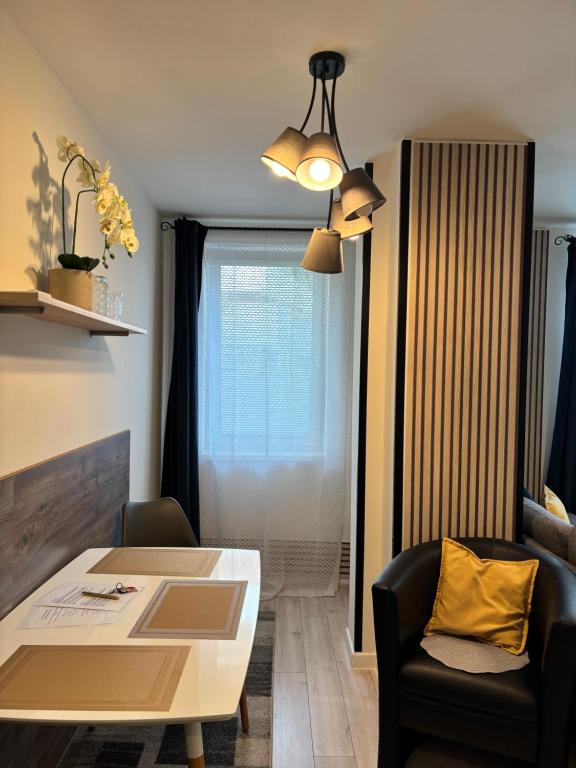 a living room with a table and chairs and a window at Apartmán CENTRAL, free parking in Banská Bystrica