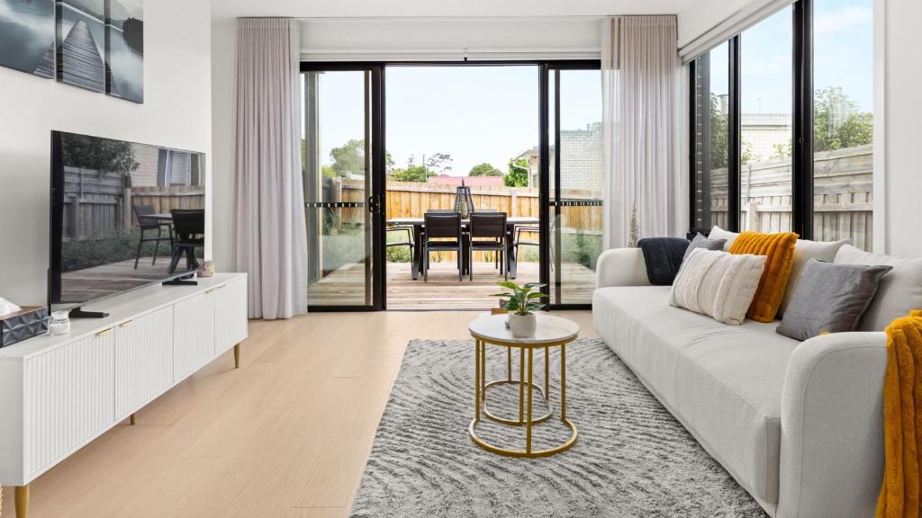 a living room with a white couch and a table at Fleetwood Atelier in Frankston South
