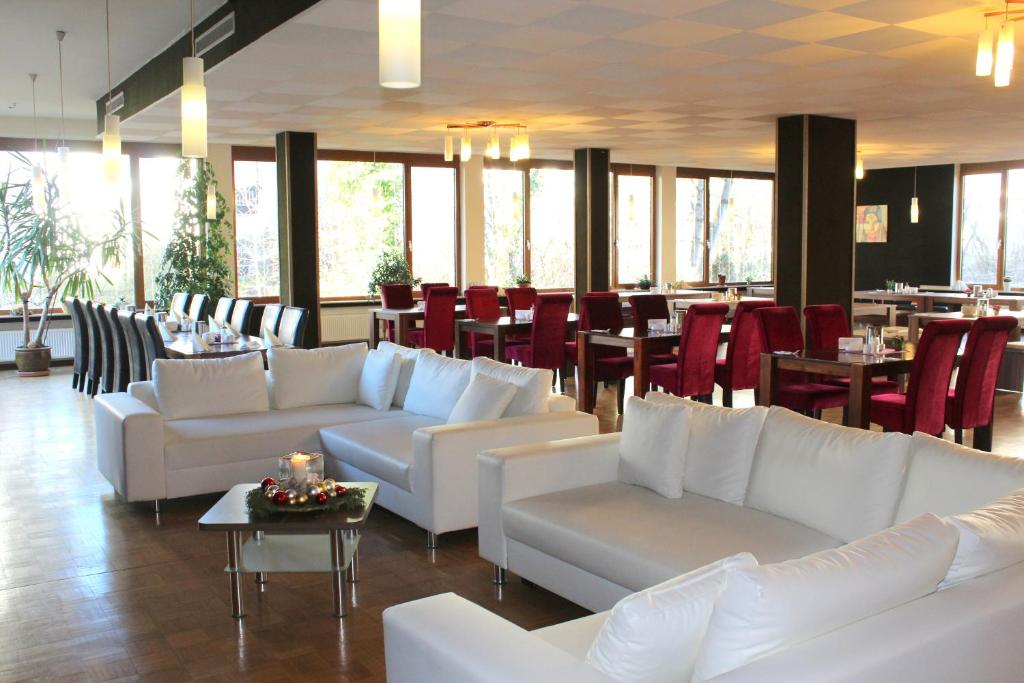 a living room filled with tables and chairs at Hotel Atlas Sport in Garmisch-Partenkirchen