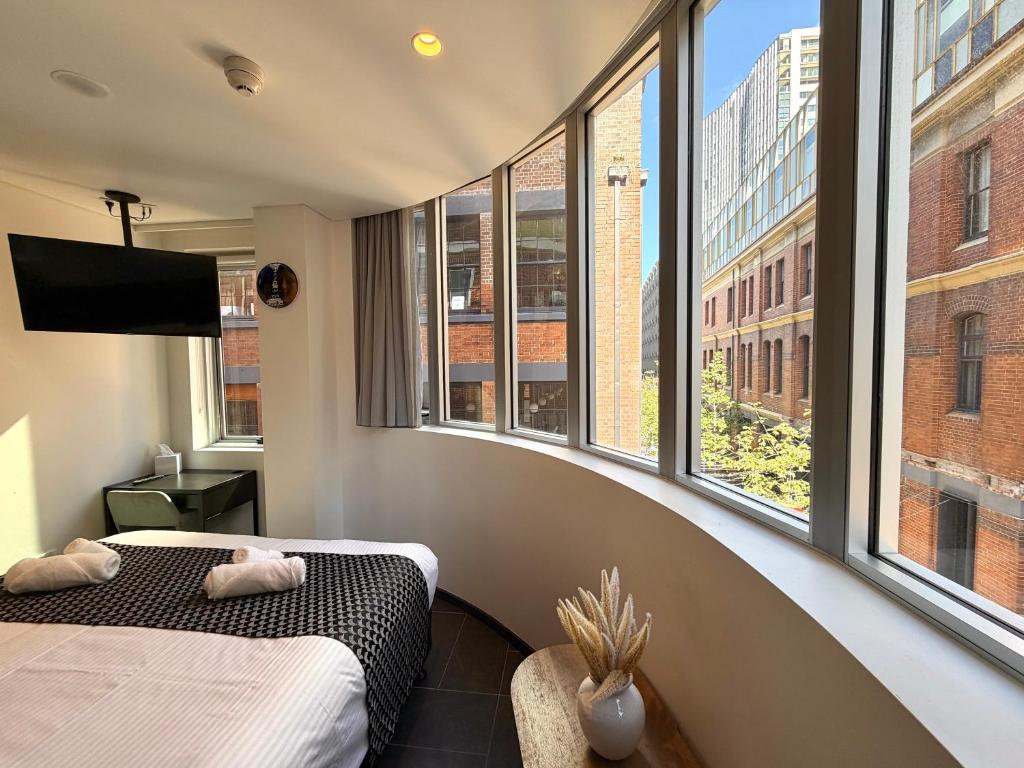 a room with two beds and a large window at Spice Serviced Apartments in Sydney