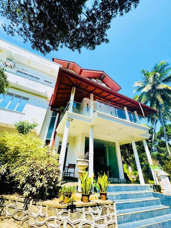 a house with a staircase in front of it at Sampath Grand Hotel in Mawanella