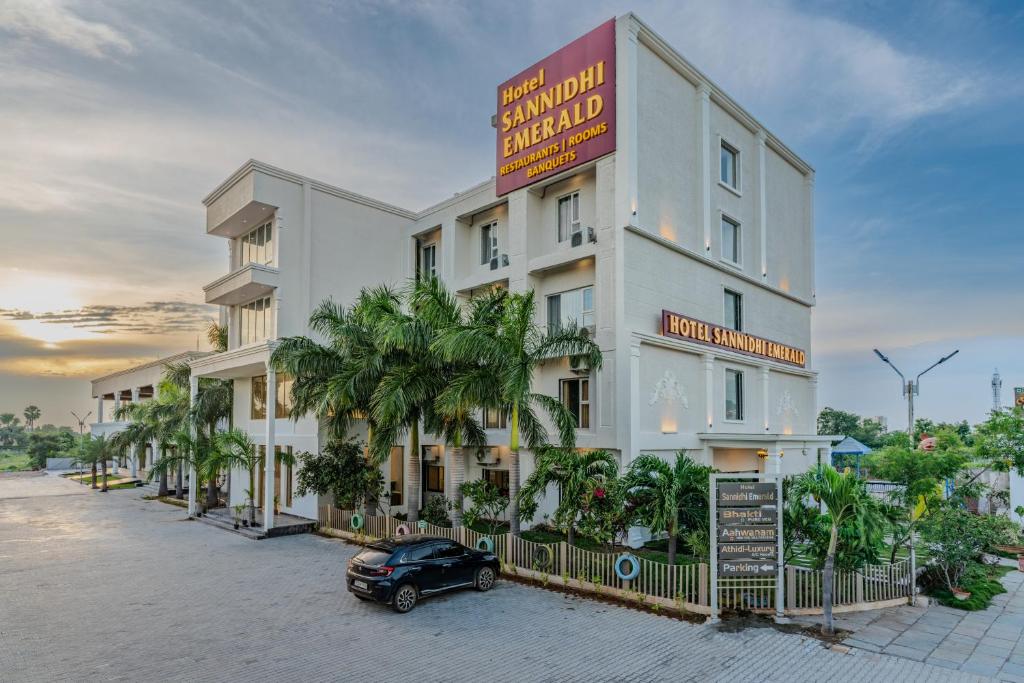 a building with a car parked in front of it at Hotel Sannidhi Emerald in Raigīr
