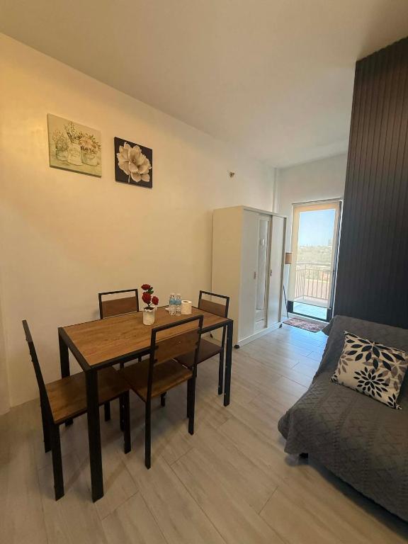 a dining room with a table and chairs and a bed at RF Condotel in Mactan Island