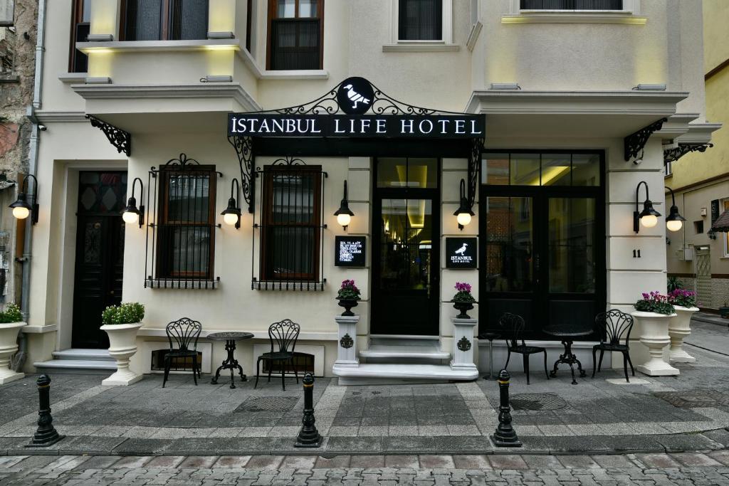 a hotel with a table and chairs in front of a building at Istanbul Life Hotel in Istanbul