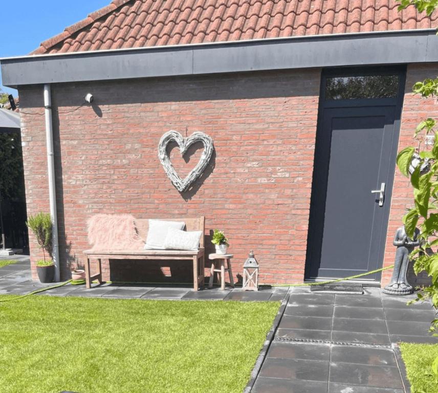 a bench with a heart on the side of a brick building at Buitenplaats Herkingen 25-A in Herkingen