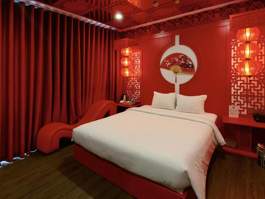 a red bedroom with a large bed and a chair at Min Boutique Hotel in Hà Ðông