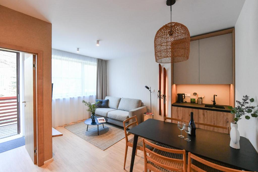 a living room with a table and a couch at Hotel Monínec - Depandance Apartmány in Moninec