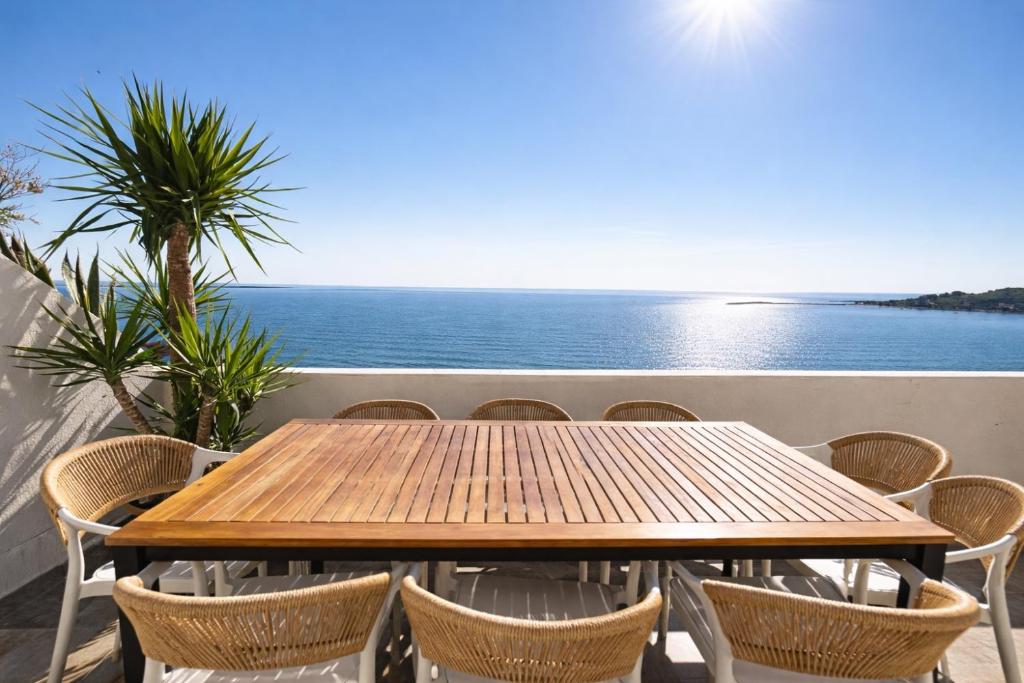 a wooden table and chairs on a balcony with the ocean at Owen Rooftop in Shëngjin