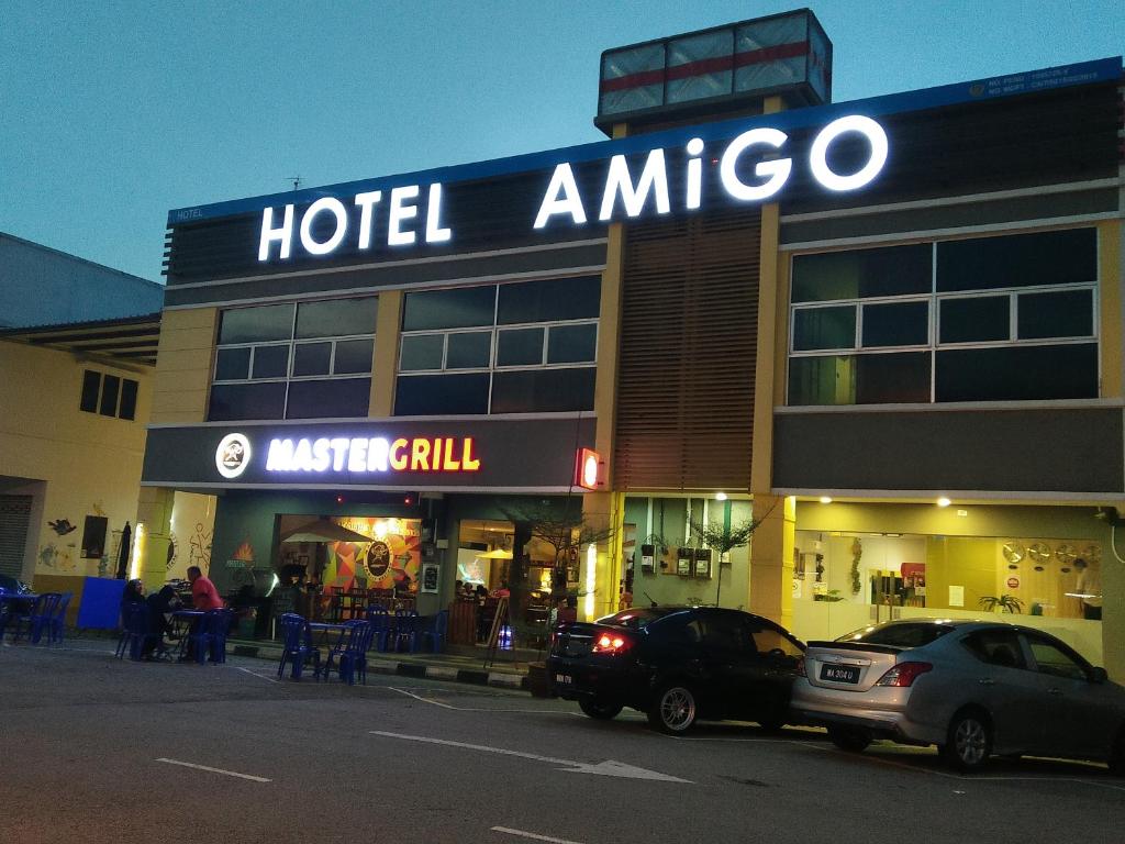 a hotel amoco with cars parked in front of it at Amigo Hotel in Seri Iskandar