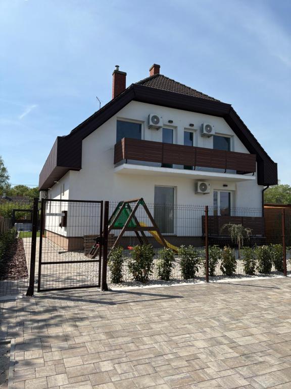 a house with a playground in front of it at Ady80 in Balatonmáriafürdő