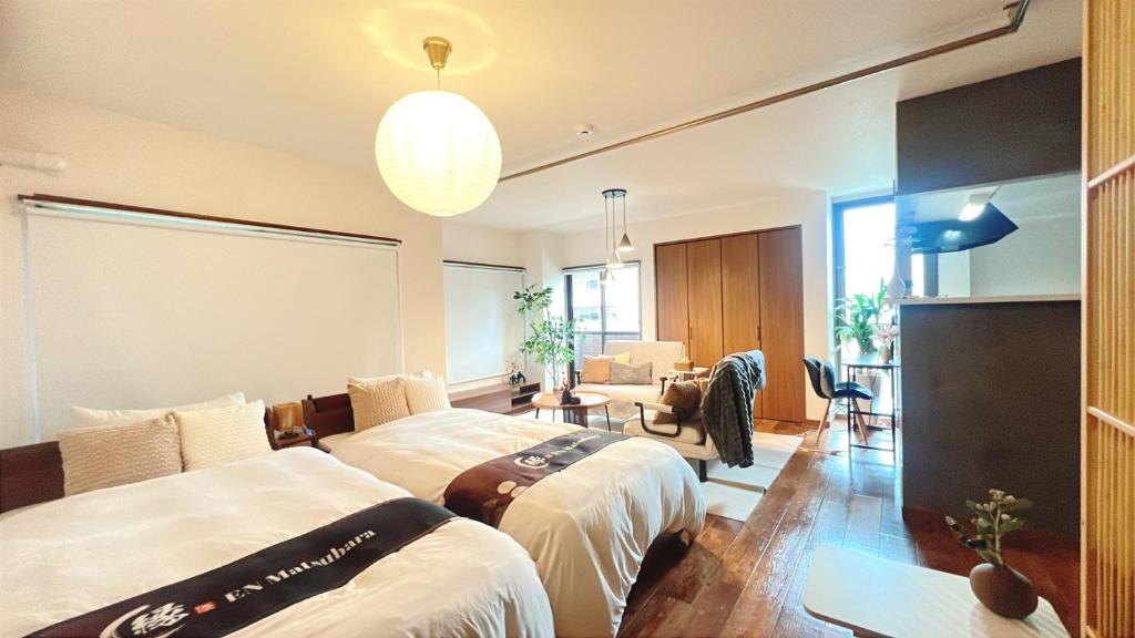 a bedroom with two beds and a living room at EN Matsubara in Kagoshima