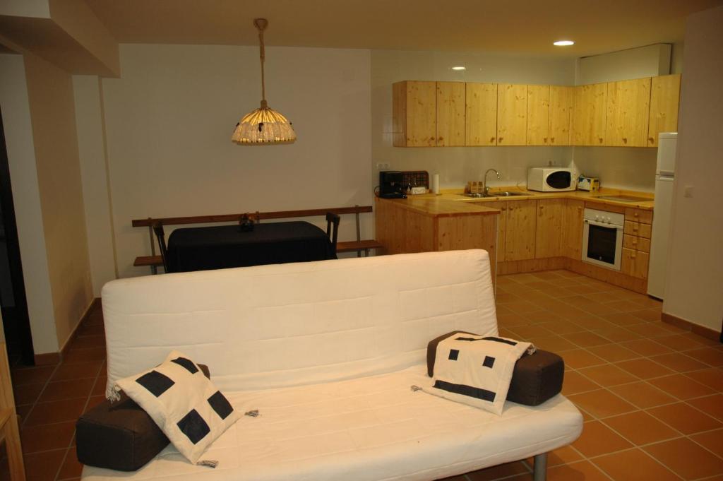 uma sala de estar com um sofá branco e uma cozinha em Cal Marroso em Montsonis