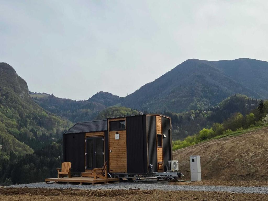 a tiny house on a hill with mountains in the background at Lahod Tiny House by Tiny Away in Žalec