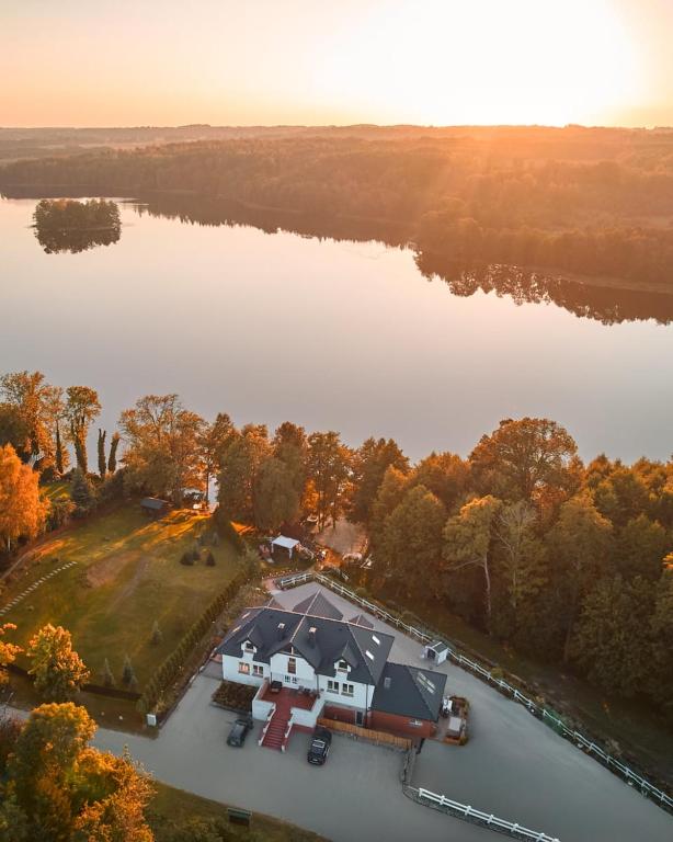 an aerial view of a large house on a lake at Królowa Kaczek - własna plaża, pomost, sauna z widokiem na wodę i sala warsztatowa in Sorkwity