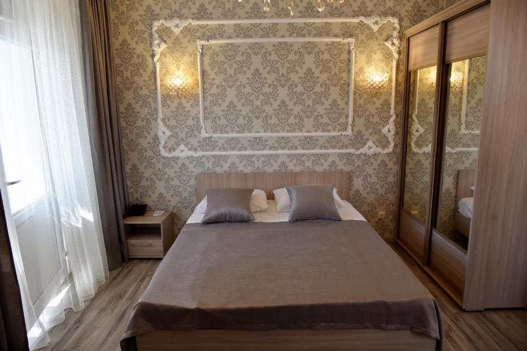 Un dormitorio con una cama y una pared. en Hotel Gloria, en Kostanái