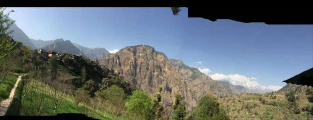 a view of a mountain range with a train at Asaka Lodge in Kasol