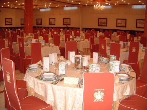 a dining room with a table and chairs with plates at Hotel Begoña Park in Gijón