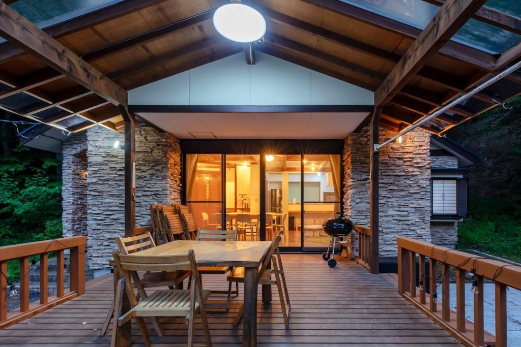 a wooden deck with a table and chairs at BASE CAMP Kitakaruizawa in Naganohara
