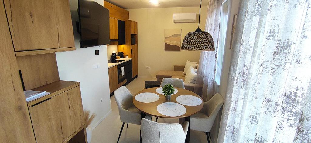 a small apartment with a table and chairs and a kitchen at MEDA Apartman in Sárvár