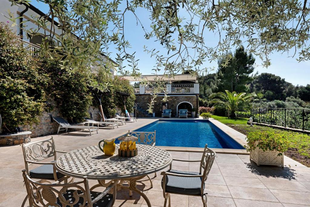 a patio with a table and chairs next to a pool at Appartamento Villa Antonia in Marina di Andora