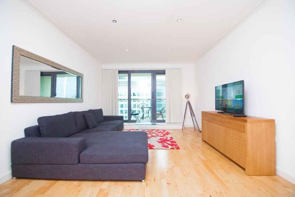 a living room with a couch and a tv at Horizon Canary Wharf Apartments in London