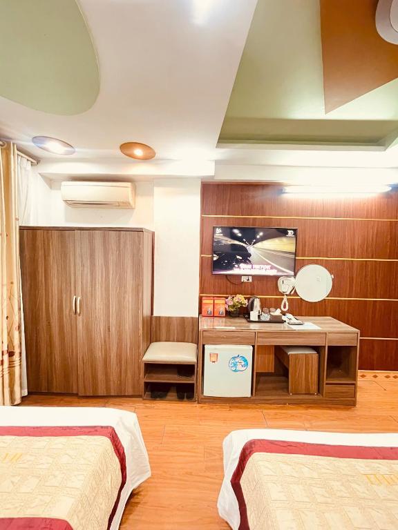 a hotel room with two beds and a television at Hà Thành Luxury Hotel in Hanoi