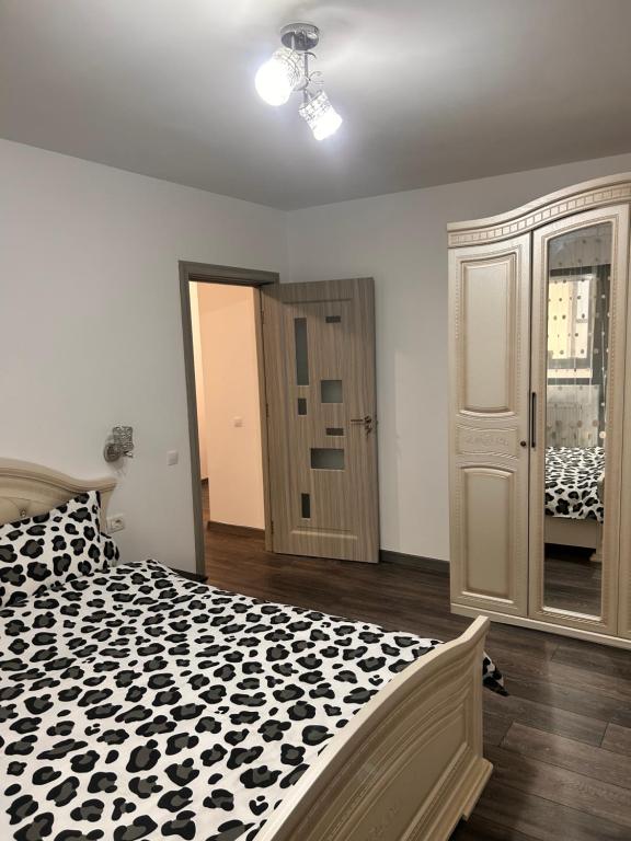 a bedroom with a black and white comforter on a bed at D&D New Residence in Piteşti