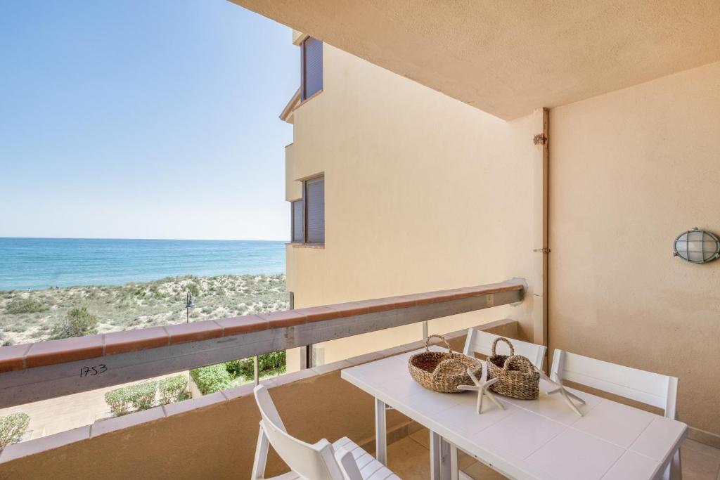 a balcony with a table and chairs and the ocean at Golf Mar I H5 in Pals