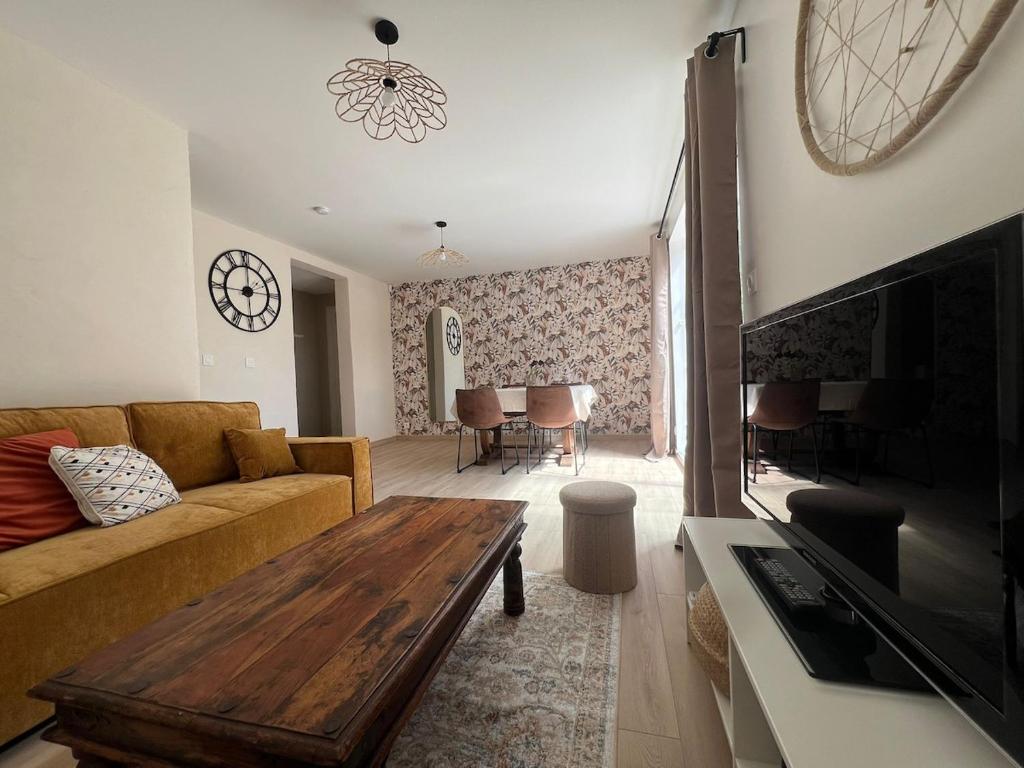 a living room with a couch and a table at Cocon nature - Appartement 1 chambre - 4 personnes in Berstett
