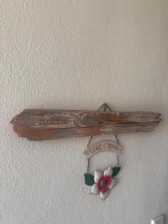 a wooden sign hanging on a wall with flowers at Antique Apartment in Afitos