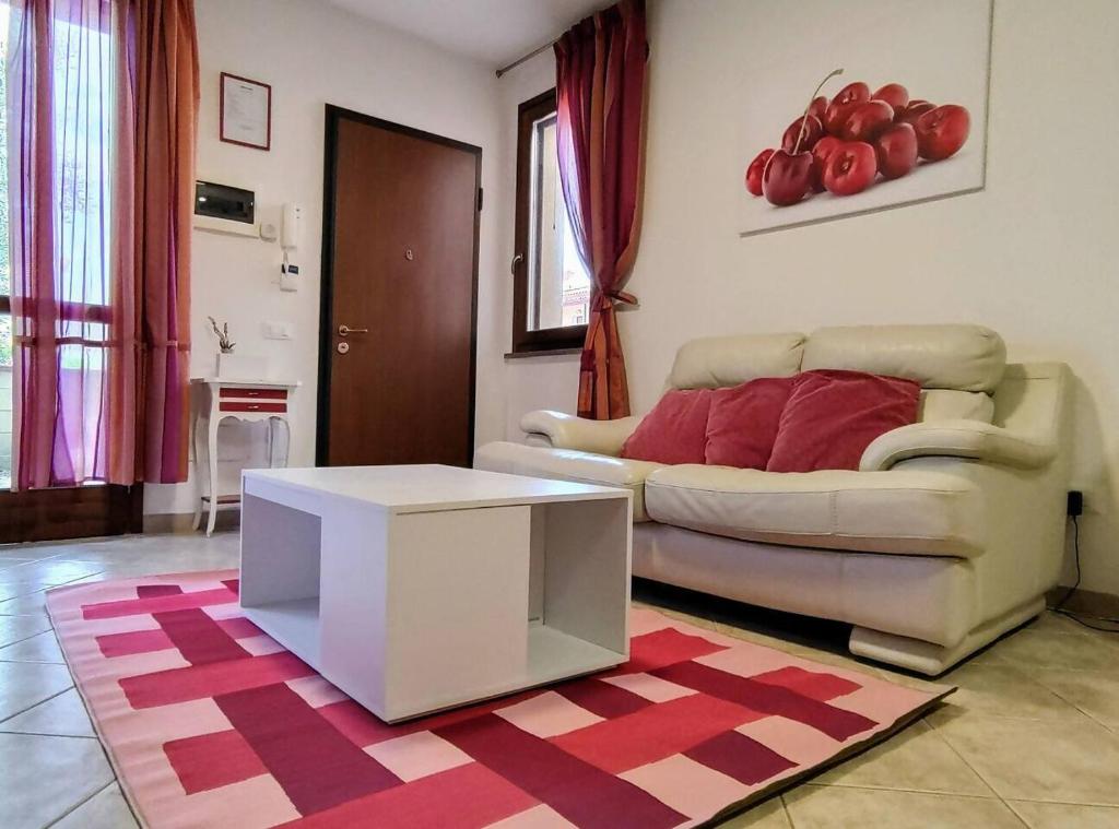 a living room with a couch and a table at Cherry House: Giardino Privato & Relax vicino Pisa in Ponsacco
