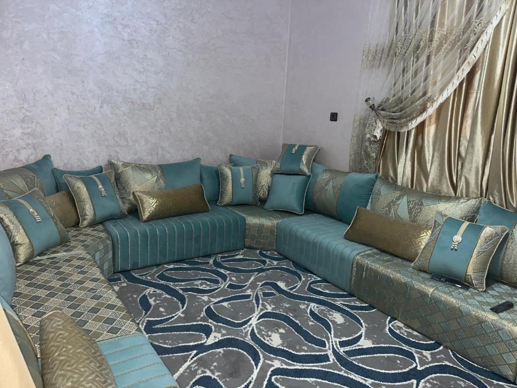 a living room with a blue couch with pillows at Rachid in Oulad Akkou