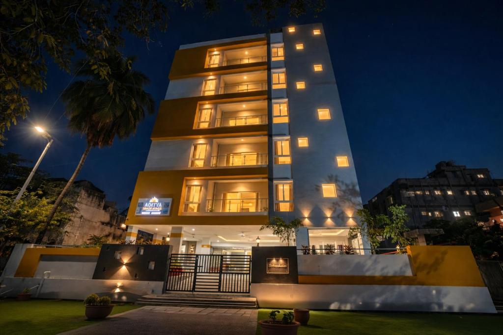 a tall building with lights on it at night at ADITYA BEACH SUITES in Visakhapatnam