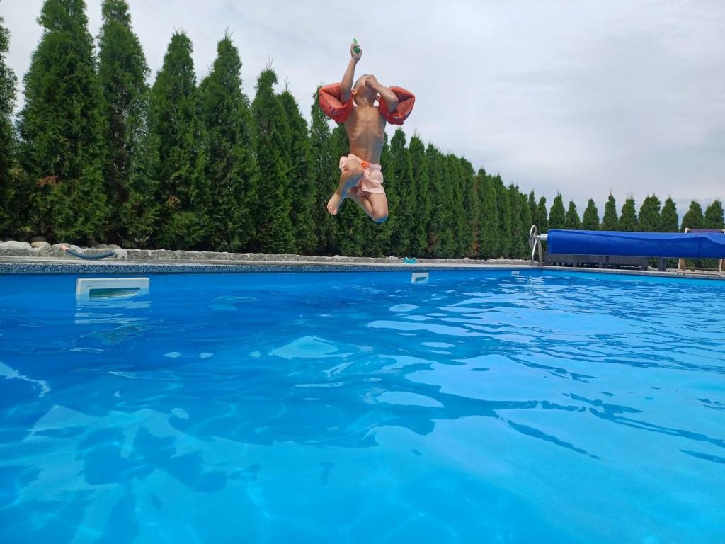 a man jumping in the air over a swimming pool at Basen z podgrzewaną wodą jacuzzi dmuchaniec sala zabaw WSZYSTKO W CENIE POBYTU in Białka Tatrzańska