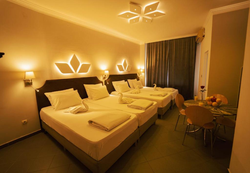 a hotel room with two beds and a table at Apartman 4B H Pozarevac in Požarevac