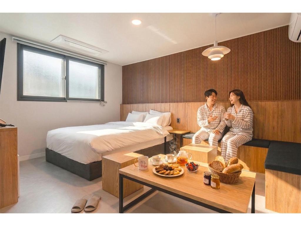 a man and woman sitting in a hotel room at Restia Hotel Suwon Station in Suwon