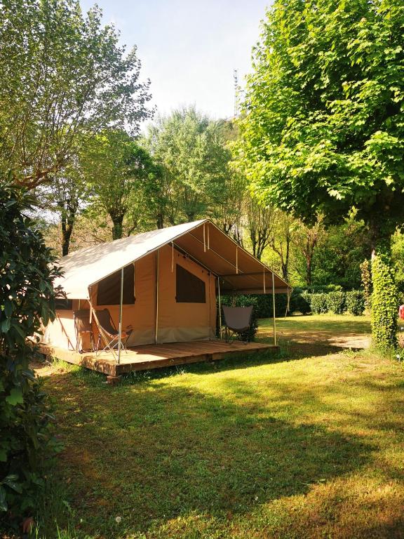 a tent in a field with trees and grass at Camping le Terriol - Onlycamp in Cajarc