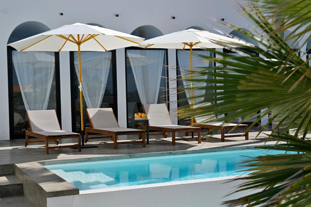 a group of chairs and umbrellas next to a pool at Casa Alisios Sea View Villa private Infinity Pool Sunsets in La Pared