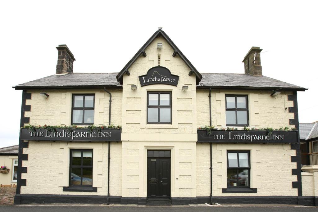 un edificio blanco con entrada a la posada Lindisfarne en The Lindisfarne Inn - The Inn Collection Group, en Beal
