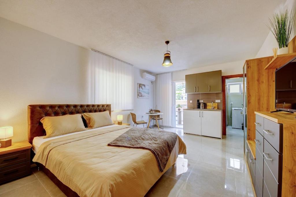 a bedroom with a large bed and a kitchen at Ferienwohnung Nike's in Dobra Voda